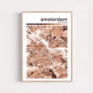 May include: A framed print featuring a detailed map of Amsterdam, Netherlands, in shades of brown. The city name is displayed at the top, with the country below. Coordinates are shown at the top left. The map is encased in a light brown wooden frame.