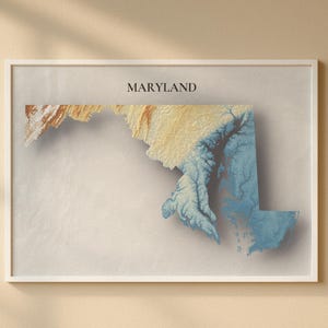 Puede incluir: Una impresión enmarcada del estado de Maryland, con un mapa topográfico en tonos de azul, amarillo y marrón. La palabra "MARYLAND" está impresa en negro en la parte superior. La obra de arte se muestra en un marco blanco sobre un fondo beige.
