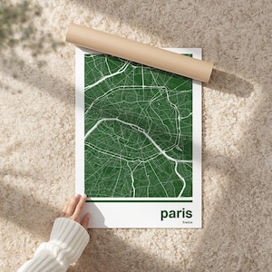 Puede incluir: Un mapa verde y blanco de París, Francia, impreso en un póster blanco. El mapa muestra las calles y los monumentos de la ciudad en blanco sobre un fondo verde. La palabra "paris" está impresa en verde en la parte inferior, con "france" debajo.