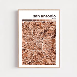 Puede incluir: Una impresión enmarcada con un mapa de San Antonio, Texas. El mapa está representado en tonos marrones y blancos, con el nombre de la ciudad y el estado en la parte superior. La impresión incluye las coordenadas 29.4241° N 98.4936° W.