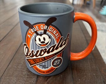 Tazza OSWALD The Lucky Rabbit Disney Parks. Ceramica grigio/arancione. 16 oz Est 1927