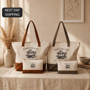 a set of two tote bags and a small bag, all featuring the same design and text, placed on a table.