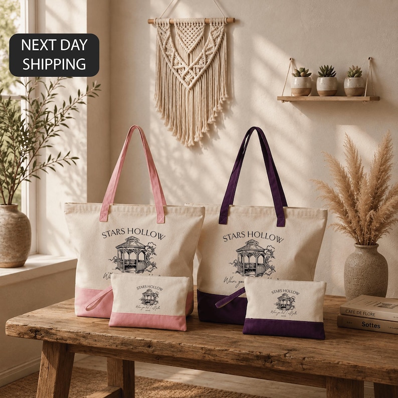a set of four tote bags with the text "STARS HOLLOW" printed on them, placed on a wooden table. The bags are accompanied by a small bag and a larger bag, all of which are white. The setting includes a window, a wall with a hanging decoration, and some potted plants. The image also includes text that reads "NEXT DAY SHIPPING".
