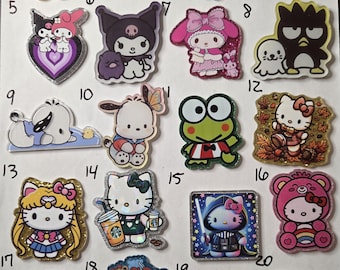 May include: A collection of twenty numbered acrylic pins featuring various Sanrio characters including Hello Kitty, My Melody, Kuromi, Pompompurin, Cinnamoroll, Keroppi, and Pochacco, displayed on a white background with glitter and holographic accents.