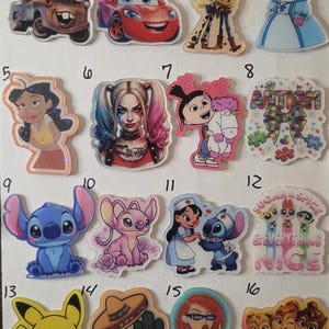 May include: A collection of sixteen acrylic character charms arranged in a grid, featuring various animated figures, including Mater, Lightning McQueen, Woody, Jessie, Max, Harley Quinn, Agnes, Stitch, Angel, Pikachu, and the Chipettes with printed text.