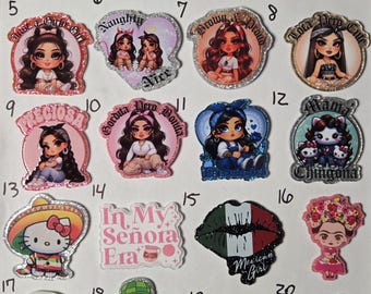 May include: A collection of twenty glittery acrylic charms featuring various cartoon characters, stylized figures, and text-based designs including Homies, In My Señora Era, and Te Calmas O Te Calmo, arranged in a numbered grid on a white background.