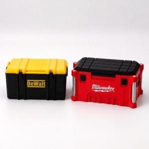 May include: Two toolboxes, one yellow and black with "DeWalt" printed on the front, and a red and black one with "Milwaukee" printed on the front. Both toolboxes are rectangular with a handle on top.