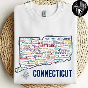 Puede incluir: Sudadera blanca con un mapa detallado de Connecticut, con nombres de ciudades y puntos de referencia. El contorno del estado es azul, con la palabra "CONNECTICUT" en la parte inferior. Una rosa de los vientos está abajo a la izquierda.