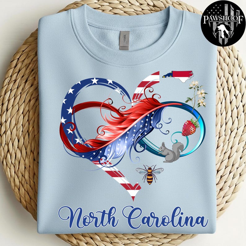 May include: A light blue sweatshirt featuring a graphic of an infinity heart symbol colored with red, white, and blue stripes and stars. The design includes a North Carolina state map, a strawberry, a squirrel, a bee, and the text North Carolina.