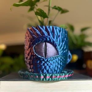 May include: A set of three ceramic mugs with a speckled, matte finish. Each mug features a different color: light blue, cream, and gray. The mugs have a simple, modern design and a comfortable handle.