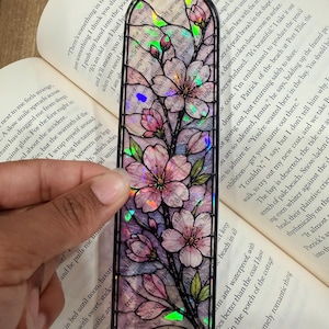Transparante boekenlegger met glas-in-lood bloemenmotief en glanzende holografische afwerking.