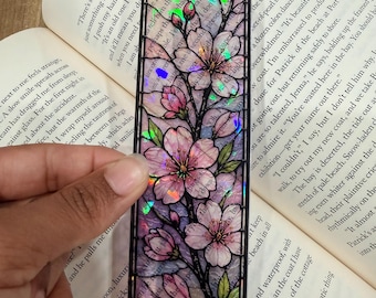Marcapáginas transparente con diseño floral de vidriera y acabado holográfico brillante.