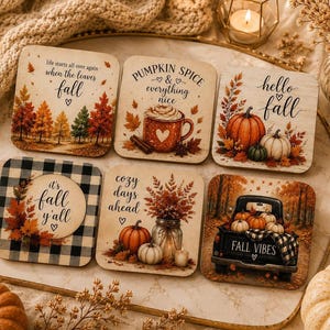 Könnte beinhalten: Ein Set aus sechs quadratischen Untersetzern mit herbstlichen Illustrationen und Texten. Die Motive zeigen einen Wald mit dem Text life starts all over again when the leaves fall, eine Tasse mit pumpkin spice and everything nice, Kürbisse mit hello fall, ein Karomuster mit it's fall y'all, ein Glas mit cozy days ahead und einen Truck mit fall vibes.