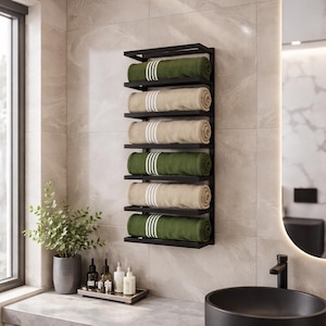 May include: A wall-mounted black metal towel rack in a bathroom, displaying rolled towels. The rack features six shelves with alternating green and beige towels, each with white stripes. The bathroom has a modern design with a round mirror and a black sink.
