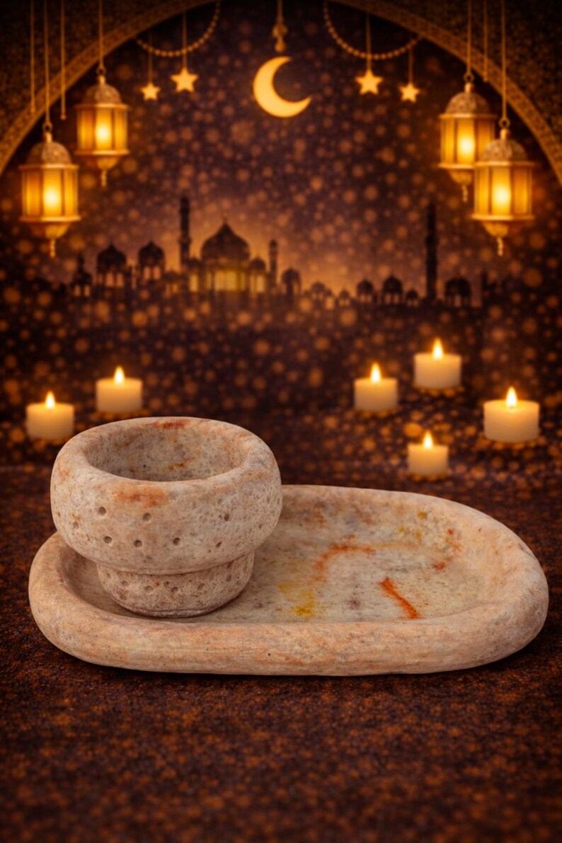 Puede incluir: Un porta incienso de piedra beige con una bandeja ovalada a juego. El soporte tiene una abertura circular. El fondo presenta velas, linternas y una luna creciente, evocando un tema oriental.