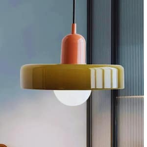 May include: A modern pendant light fixture with a round, olive-green shade and a white globe light. The fixture has a burnt orange top and a black cord. The design is minimalist and contemporary.