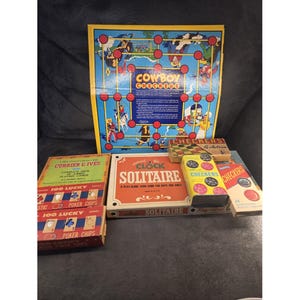 May include: A collection of vintage board and card games including a Cowboy Checkers game board, a Clock Solitaire box, two boxes of 100 Lucky Poker Chips, and three small boxes of checkers. The items feature colorful graphic designs and text.
