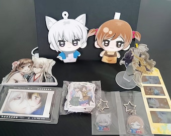 Puede incluir: Una colección de artículos de anime que incluye dos recortes grandes de personajes, un soporte de acrílico transparente, un marco de tira de película, una pila de pegatinas en una bolsa de plástico y dos llaveros en forma de estrella.