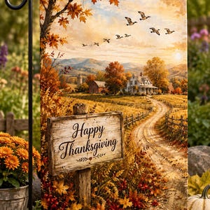 Op de afbeelding: Een rechthoekige tuin vlag met een landelijk herfstlandschap met een zandpad, een boerderij en een zwerm vogels in een zonsonderganglucht. Een houten bord op de voorgrond toont de tekst Happy Thanksgiving in zwart cursief schrift.