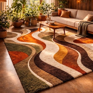 以下が含まれることがあります： 黒い持ち手と「But First, Coffee」のテキストが黒い太字で書かれた白いセラミックマグ。マグカップはぼやけた背景に置かれており、居心地の良い環境を示唆しています。