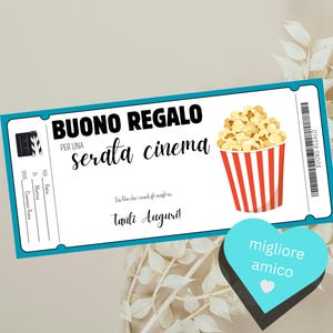 Könnte beinhalten: Ein Gutschein für einen Kinoabend, mit blauem Ticketdesign und einer Popcorn-Eimer-Illustration. Der Gutschein lautet "BUONO REGALO" und "serata cinema". Ein blaues Herz mit "migliore amico" ist ebenfalls vorhanden.