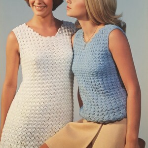 May include: A white sleeveless crochet dress with a scalloped neckline and a light blue sleeveless crochet top with a scalloped neckline paired with a solid tan skirt. Both tops feature a textured, repeating stitch pattern throughout the fabric.