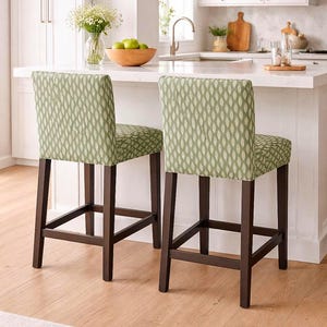 Könnte beinhalten: Ein Set aus drei Keramikbechern mit gesprenkelter, matter Oberfläche. Die Becher sind in den Farbtönen Creme, Hellgrau und Dunkelgrau gehalten. Jeder Becher hat ein schlichtes, minimalistisches Design und einen abgerundeten Henkel. Die Becher sind aufeinander gestapelt.