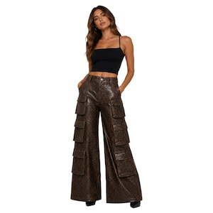 May include: A woman wearing a black crop top and brown faux leather cargo pants. The pants have multiple pockets and a wide-leg design. The pants have a snakeskin pattern.