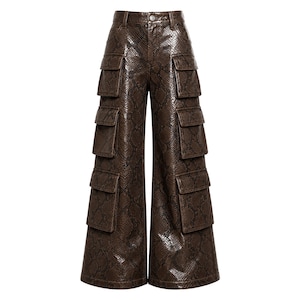 May include: Brown faux leather cargo pants with a snakeskin pattern. The pants have multiple pockets on the legs and a wide leg design. The pants are shown on a white background.