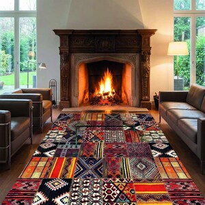 Könnte beinhalten: Ein farbenfroher Patchwork-Teppich mit geometrischen Mustern in Rot-, Orange-, Schwarz- und Blautönen. Der Teppich liegt vor einem Kamin mit brennendem Feuer und schafft eine warme Atmosphäre. Der Raum verfügt auch über Ledermöbel.