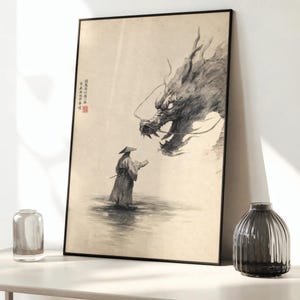 Peut inclure: Une impression d'art encadrée représentant une illustration à l'encre noire d'une personne portant un chapeau conique face à un grand dragon détaillé. L'œuvre inclut une calligraphie chinoise verticale et un petit sceau rouge sur fond clair.