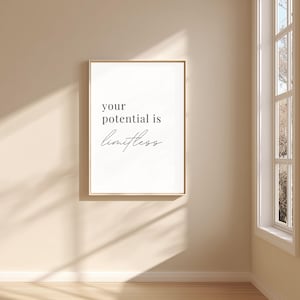 Könnte beinhalten: Gerahmter Druck mit den Worten "your potential is limitless" in schwarzer Schrift auf weißem Hintergrund. Der Rahmen hat eine helle Holzfarbe, und der Druck hängt an einer beigefarbenen Wand.