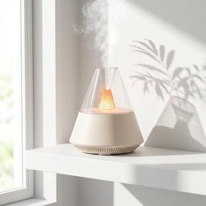 Peut inclure: Un diffuseur d'huiles essentielles beige avec un sommet conique transparent, émettant une vapeur. La base est beige clair, et le sommet est transparent, laissant la lumière intérieure briller. Le diffuseur est posé sur une étagère blanche.