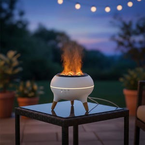 Peut inclure: Un foyer extérieur sphérique blanc avec un effet de flamme. Le foyer a trois pieds en bois et repose sur une table avec un plateau en verre. L'arrière-plan présente une scène extérieure floue avec des guirlandes lumineuses.