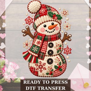 May include: A DTF transfer featuring a snowman wearing a red and green plaid hat and scarf, decorated with holly, berries, and snowflakes. The snowman has a carrot nose, black button eyes, and three black buttons on its torso. Text reads READY TO PRESS DTF TRANSFER.