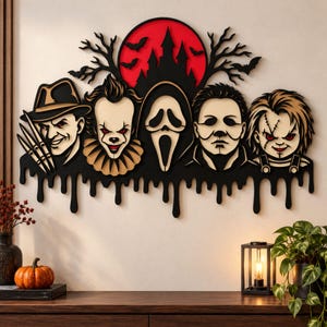 Puede incluir: Una pieza de arte de pared de madera con cinco personajes de películas de terror en negro, beige y rojo. El diseño incluye una luna roja, una silueta de castillo negro, murciélagos y una base negra que gotea. Los personajes son Freddy, Pennywise, Ghostface, Michael Myers y Chucky.