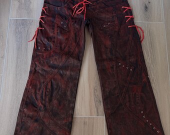 Pantalones anchos con cordones rojos desgastados