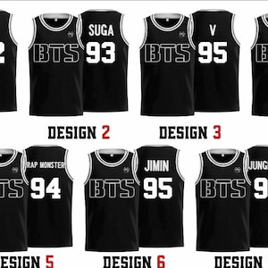 Könnte beinhalten: Schwarze Basketball-Trikots mit weißem Besatz und dem Text "BTS". Jedes Trikot hat einen anderen Namen und eine andere Nummer: Jin 92, Suga 93, V 95, J-Hope 94, Rap Monster 94, Jimin 95 und Jungkook 97. Unter jedem Trikot stehen "DESIGN"-Etiketten.