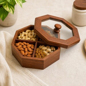 May include: A wooden serving tray with a clear glass lid, divided into four compartments filled with almonds, cashews, pistachios, and raisins. The tray is octagonal and has a dark brown finish. The lid has a wooden knob.