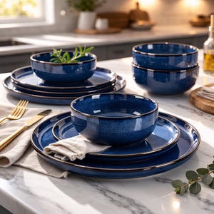 Peut inclure: Un ensemble de vaisselle en céramique bleu foncé avec une finition mouchetée et un bord marron foncé. L'ensemble comprend des bols et des assiettes, disposés sur un comptoir en marbre avec une serviette en lin et des couverts dorés. Vaisselle pour un usage quotidien.