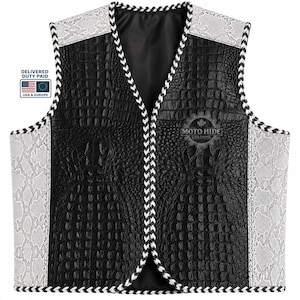 May include: A black leather vest with a crocodile texture, featuring white and grey snake-skin patterned accents on the shoulders and sides. The vest has a V-neck design and is trimmed with a black and white braided border. The Moto Hide Customs logo is visible.