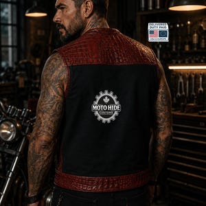 May include: A black and red leather vest with a textured, crocodile-like pattern on the shoulders and trim. The vest features the "MOTO HIDE CUSTOMS" logo on the back. The vest is worn over a black shirt and black jeans.