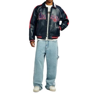 May include: A navy blue leather jacket with red and white accents, featuring embroidered text on the chest. The jacket is paired with light blue denim jeans and white sneakers. The overall style is casual and streetwear-inspired.