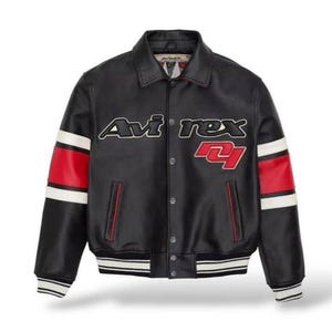 Peut inclure: Veste en cuir noire avec le texte "Avirex" en blanc et rouge. La veste a des rayures rouges et blanches sur les manches et une fermeture &agrave; boutons. Col et poignets c&ocirc;tel&eacute;s.