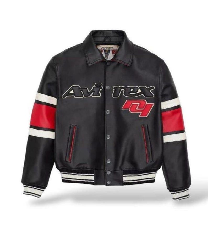 Peut inclure: Veste en cuir noire avec le texte "Avirex" en blanc et rouge. La veste a des rayures rouges et blanches sur les manches et une fermeture &agrave; boutons. Col et poignets c&ocirc;tel&eacute;s.