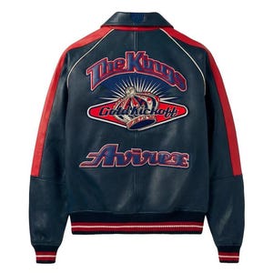 May include: Navy blue leather jacket with red accents on the shoulders and sleeves. The back features a large embroidered design with the text "The Kings", a crown, and "Gold Kickoff" and "Avirex". The jacket has a ribbed hem and cuffs.