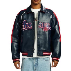 May include: Navy blue leather jacket with red and white accents. The jacket features the word "Air" in red and white lettering on the chest, and the word "Ride" with a crown logo. The jacket has a ribbed collar, cuffs, and hem.