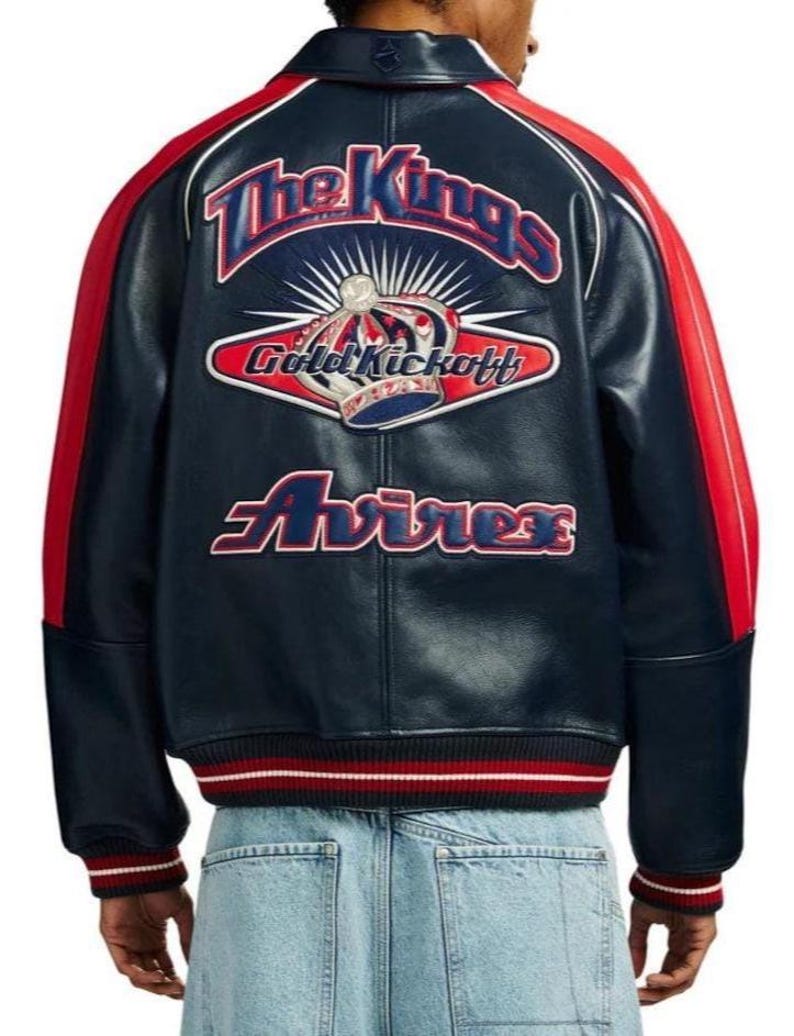 May include: A navy blue leather jacket with red and white accents. The back features the text "The Kings" above a crown graphic and the words "Gold Kickoff" and "Avirex". The jacket has a ribbed collar, cuffs, and hem.