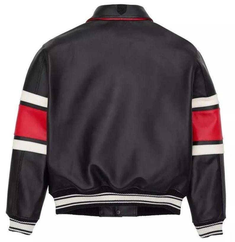 Peut inclure: Veste en cuir noire avec des d&eacute;tails blancs et rouges sur les manches. La veste a un col et des poignets c&ocirc;tel&eacute;s avec des rayures blanches et noires. Un petit embl&egrave;me est visible au dos du col.
