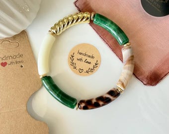 Pulseira rígida boho personalizada, feita com contas tubulares curvas, em uma estampa de leopardo dourada super em alta em 2026. O presente perfeito para qualquer ocasião.